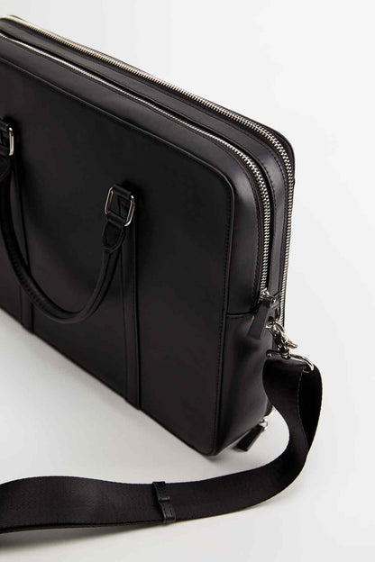 Black structured bag with front buckle strap, side zipper, and shoulder strap