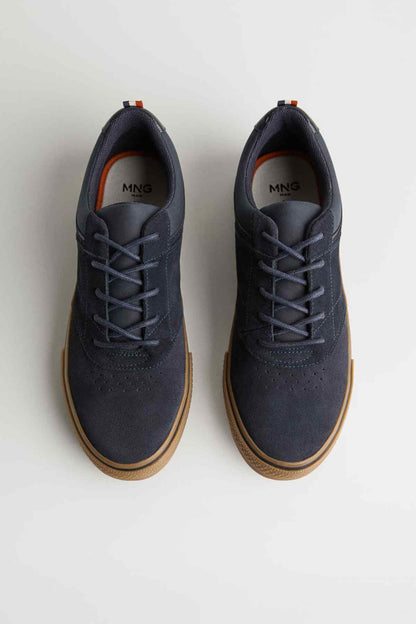 Navy sneakers showing tongue label 'MNG', lace-up design, gum soles.