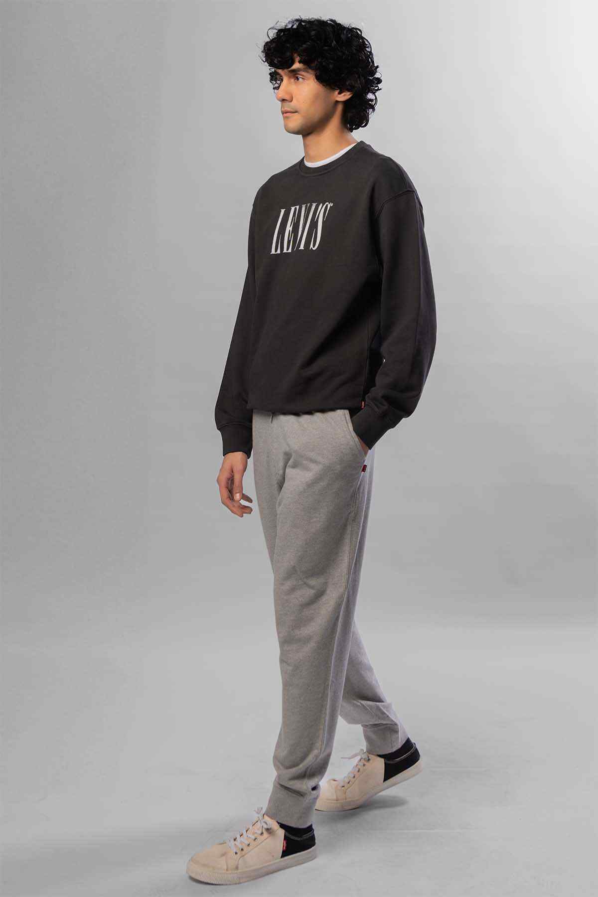 Levi's logo crewneck sweatshirt with light grey tapered joggers, side view