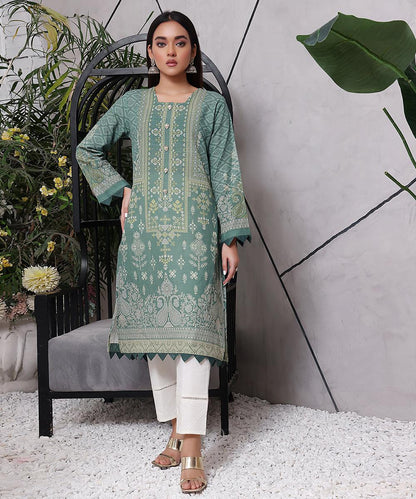 Seafoam green embroidered tunic, white pants, tan sandals, three-quarter view