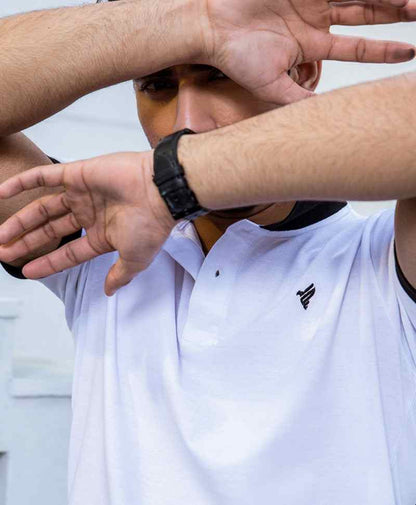 White polo shirt chest logo with black collar trim, close-up underarm sleeve