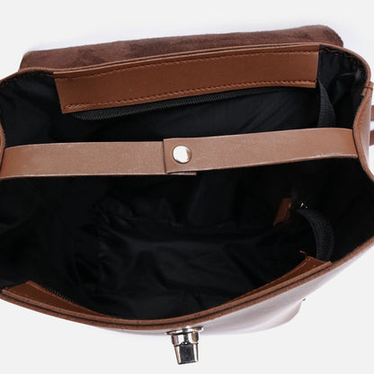 Mini backpack interior with black lining, brown trim, snap button pocket, and metal zipper pull.