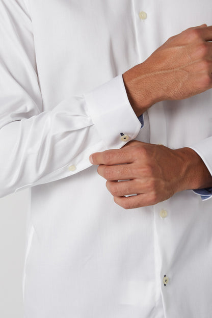 White dress shirt cuff with button closure and gold-tone detailing