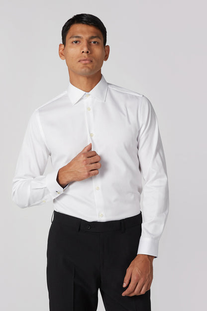 White dress shirt with button front and long sleeves, worn with black trousers