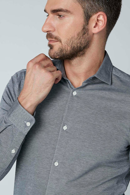 Grey button-up shirt close-up with collar, white buttons, and long sleeves