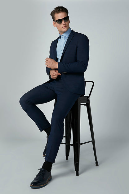 Men's navy blue suit jacket and trousers, slim fit, seated side view