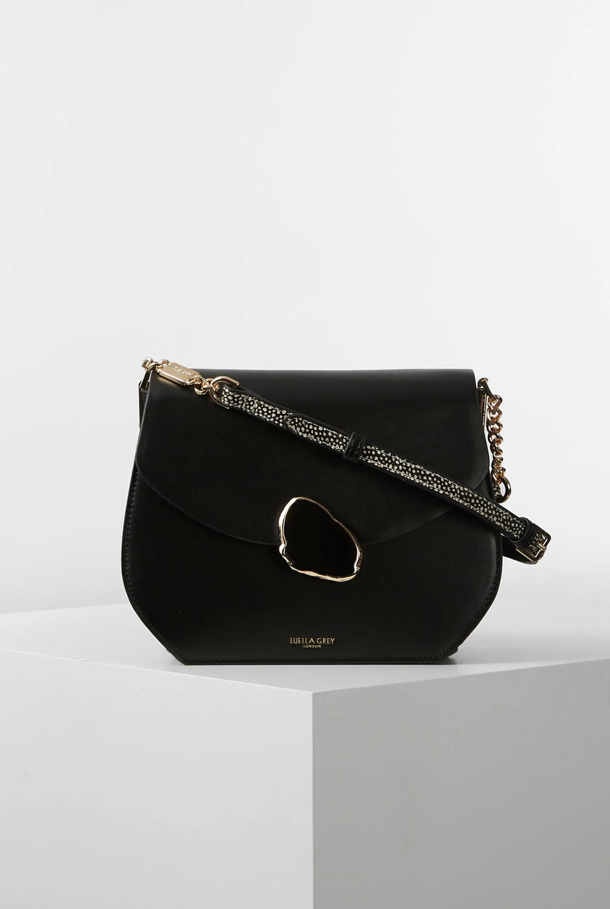 Black saddle crossbody bag with oval ring front and braided chain strap