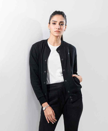 Black fitted jacket with snap-button front, long sleeves, chest logo, worn open over a white top