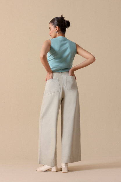 Mint sleeveless crop top with light beige high-waist wide-leg trousers, rear view