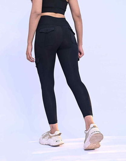 Back view black cargo leggings with side thigh pocket and tapered ankle fit.
