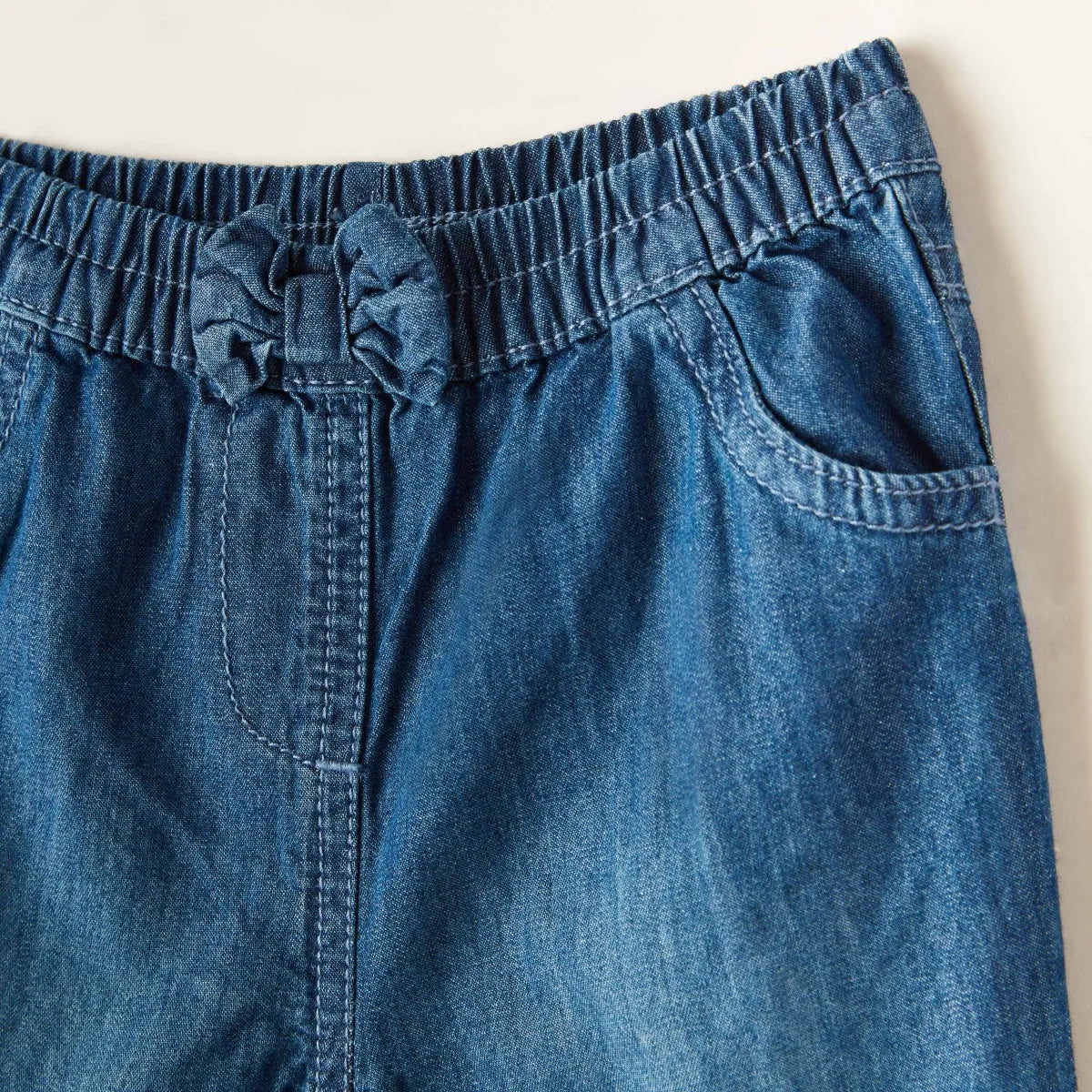 Blue denim baby pants waistband with drawstring and side patch pocket detail