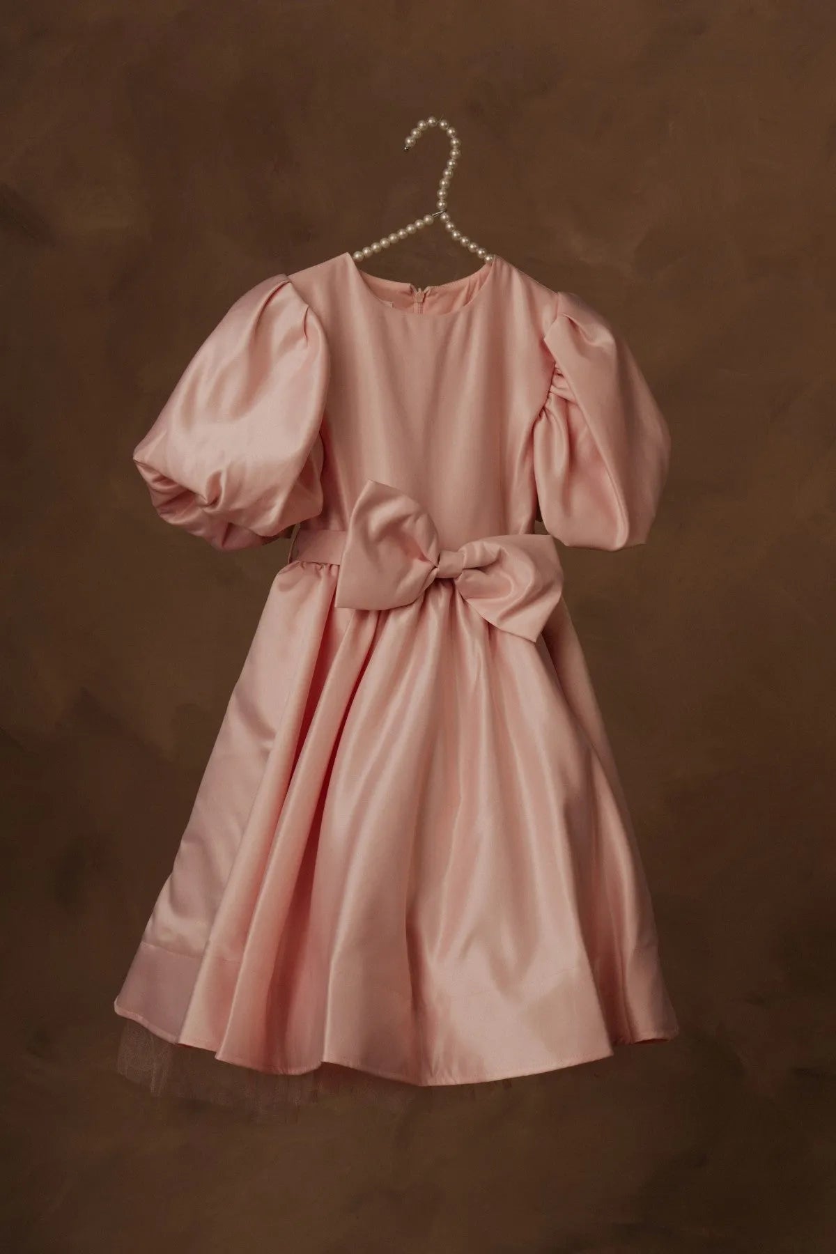 Pink puff-sleeve dress with gathered waist bow and skirt flare, on pearl hanger.