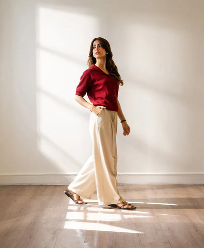 Fitted burgundy short-sleeve button-up shirt paired with light pants, front view