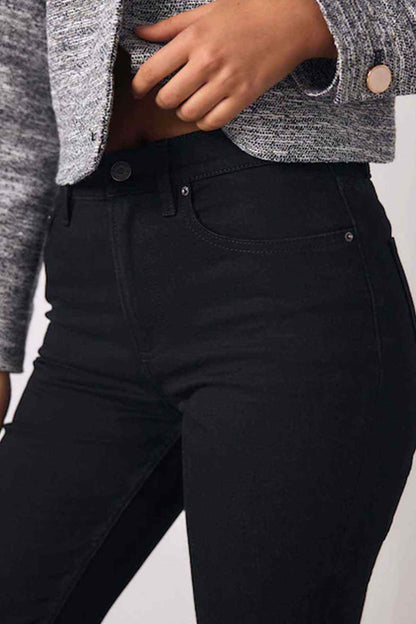 Black jeans close-up showing belt loops and stitched waistband