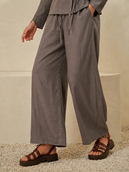 Grey wide-leg trousers with drawstring waist and relaxed fit