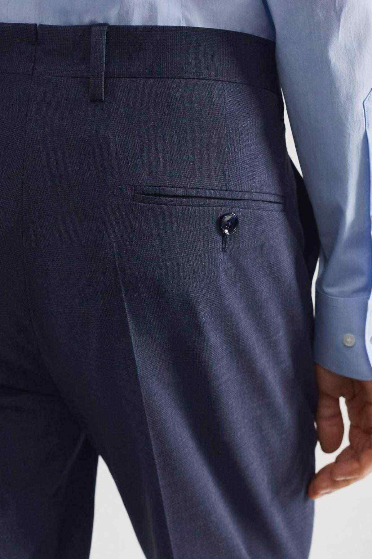Indigo blue trousers close-up of front pocket and buttoned waistband