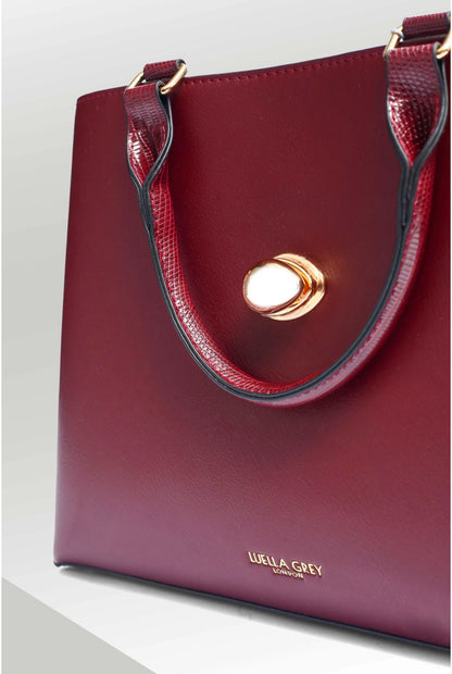 Berry tote handbag side close-up with gold clasp and top handle stitching
