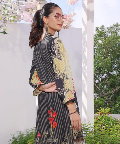 Side view patchwork tunic in black and light yellow with red florals and ornate cuffs