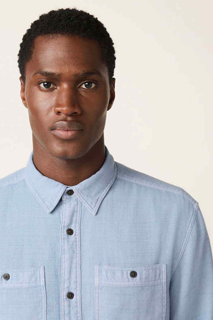 Men's light blue button-up shirt close-up of collar and chest pockets