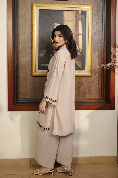 Cream kurta with maroon embroidered hem and fringed cuffs, styled with light pants
