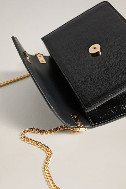 Black leather crossbody bag with flap and gold clasp detail