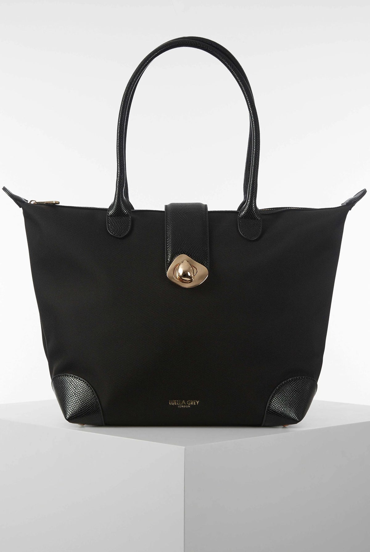 Black tote bag with dual handles and gold front clasp detail