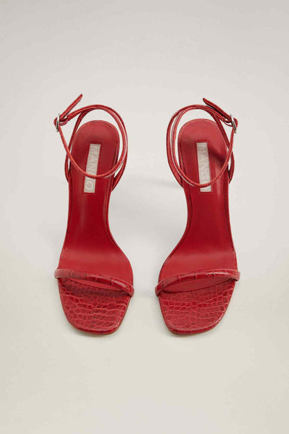 Red heeled sandals with open toe and textured crocodile-style strap detail