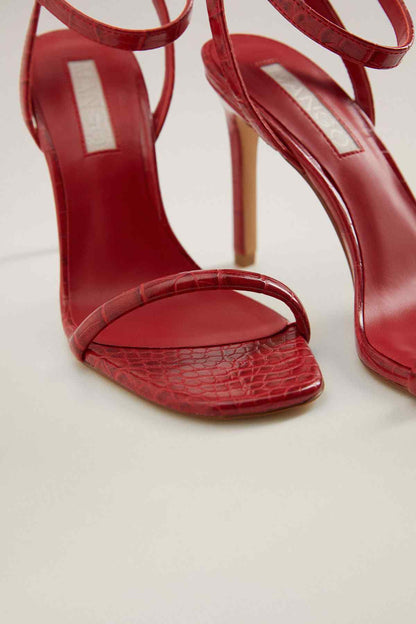 Red heeled sandals close-up with textured footbed and T-strap