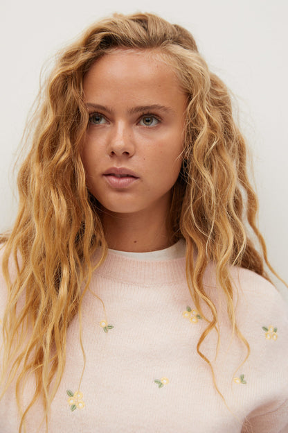 MANGO ecru knit sweater close-up with tiny floral embroidery across the chest
