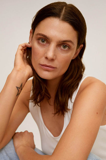 White sleeveless tank top close-up, scoop neckline and armhole detail