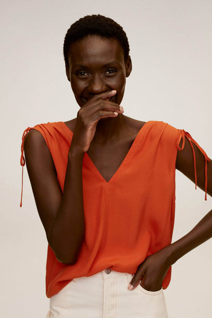 Orange sleeveless V-neck top with tie shoulder straps, front center