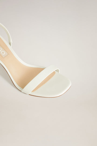 Off-white heeled sandal side view with thin ankle strap, open toe, stiletto heel.