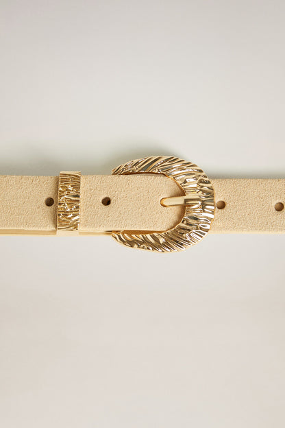 Beige belt with gold-tone oval buckle featuring engraved border
