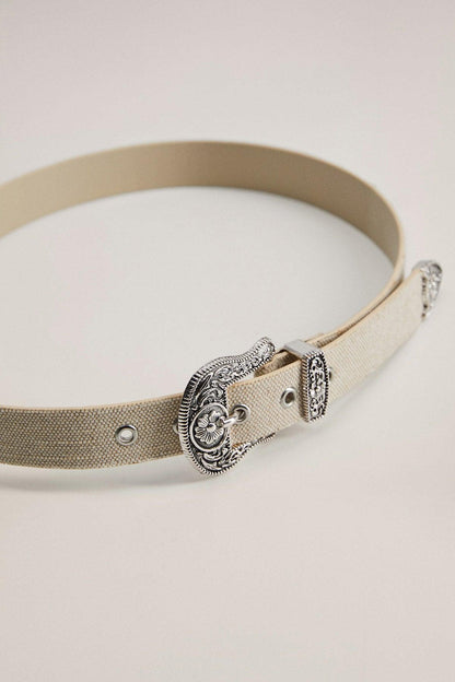 Beige canvas belt with oval ornate silver buckle and metal eyelets