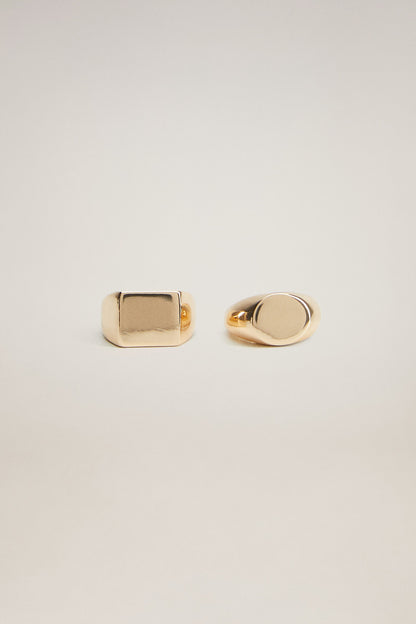 Gold-tone square signet ring and oval band ring, side-by-side