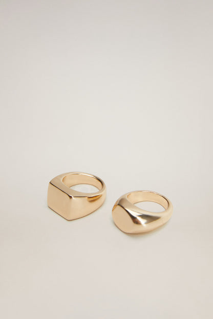 Gold-tone square signet ring and oval band ring, top-down view