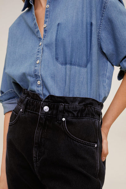 Black denim jeans close-up, button front, belt loops, and front pockets