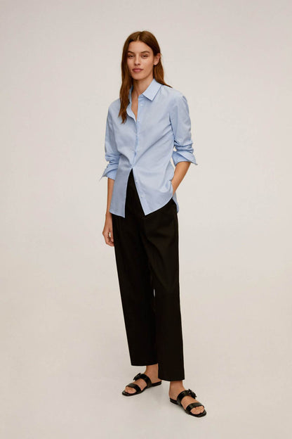 Sky blue button-up shirt with collar and long sleeves, worn with black trousers