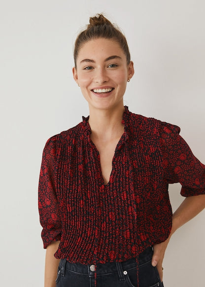 Red and dark patterned button-up blouse with collar and long sleeves