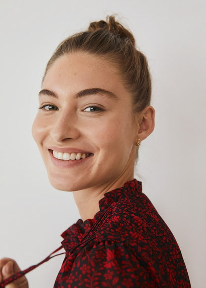 Red and dark patterned blouse with neck tie and button placket