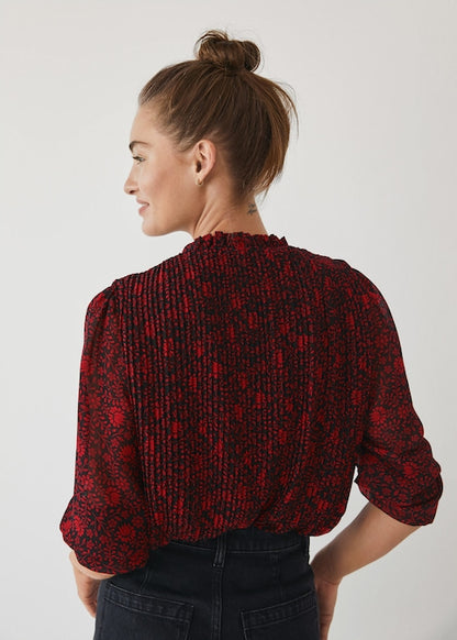 Red and dark patterned button-up blouse, back view with long sleeves