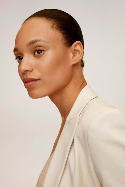 Beige blazer collar and neckline detail with single-button closure
