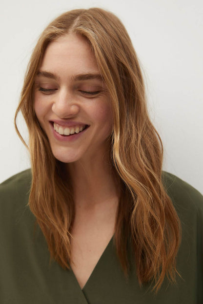 Khaki V-neck blouse with soft drape and smooth neckline