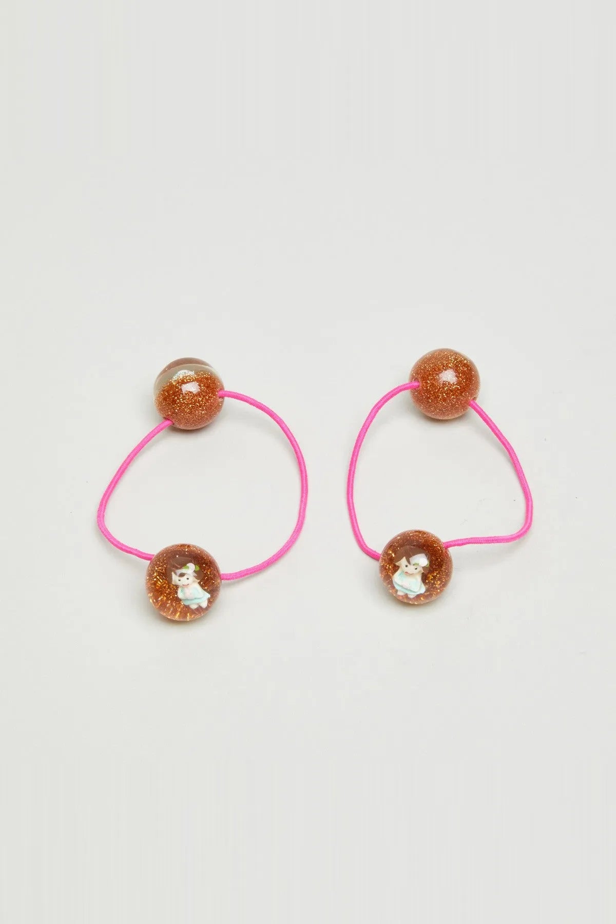 Two pink elastic hair ties with glitter brown beads and small cartoon charms