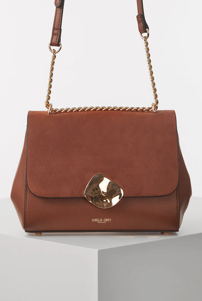 Brown flap crossbody bag with gold chain strap and metal clasp