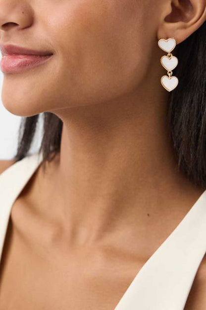 Heart drop earrings with three small heart charms, pearl-like finish, gold-tone hooks