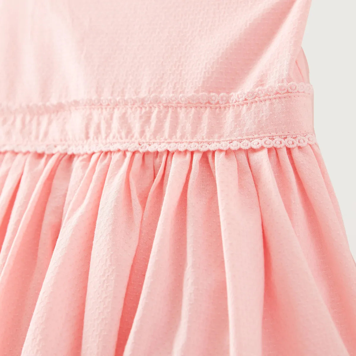 Pink dress bodice with smocked waistband and gathered pleated skirt detail
