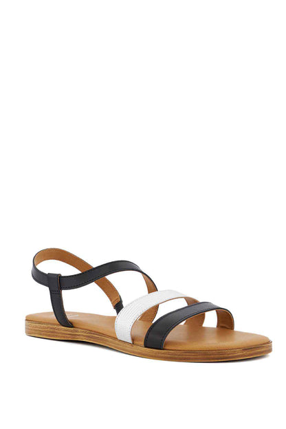 Black and white thong-style flat sandals with tan footbed and ankle straps
