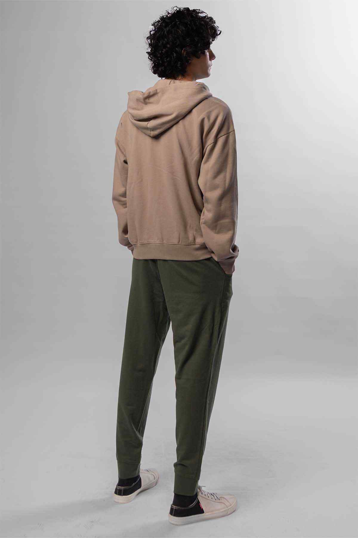 Levi's taupe pullover hoodie with hood; green jogger pants, rear view
