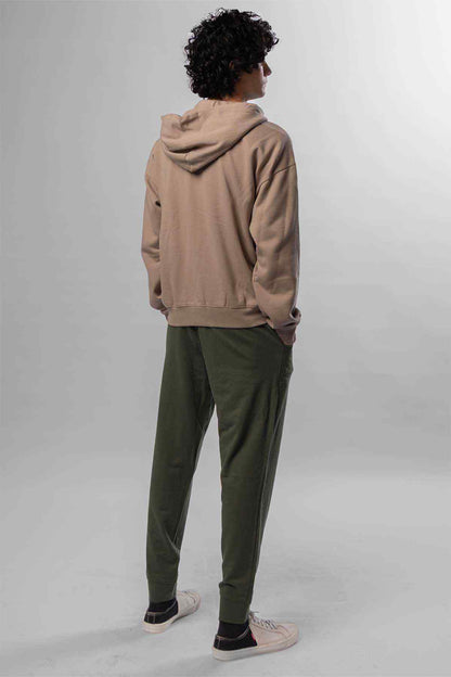 Levi's taupe pullover hoodie with hood; green jogger pants, rear view